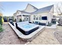 Backyard featuring a modern hot tub, outdoor seating area, landscaped yard, and a stylish exterior at 1025 Chelsea Run Ln, Apex, NC 27502