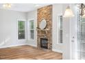 Living room featuring a stone fireplace, wood floors, recessed lights, and lots of natural light at 1100 Dotson Way, Apex, NC 27523