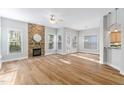 View of a living room with a stone fireplace and open floor plan with natural light at 1100 Dotson Way, Apex, NC 27523
