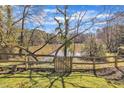 Fenced backyard with serene lake view beyond the trees at 113 Ellen Pl, Chapel Hill, NC 27514