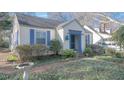 A charming house with blue trim and shutters, set in a yard with mature bushes at 1301 Clarendon St, Durham, NC 27705