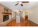 Spacious living room features a brick fireplace, wood floors, and ample natural light at 205 Fox Hollow Dr, Clayton, NC 27527