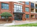 Close up of the front entrance to the brick condominium building with glass doors and an awning at 300 Finsbury # 115, Durham, NC 27703