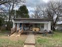 Simple home with a covered porch and ramp leading to the entrance, set in a grassy front yard at 406 S Flanner St, Burlington, NC 27215