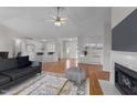 Bright living room with hardwood floors, fireplace, and open floor plan leading to kitchen with seating at 42 Galaxy Dr, Garner, NC 27529