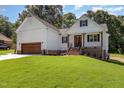 An appealing white home showcases brick foundation accents, a lush lawn, and a convenient two-car garage, perfect for Gathering living at 503 Forest Rd, Oxford, NC 27565