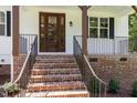 Inviting front porch with brick stairs, iron railings, and a stylish wood door, creating a warm and welcoming entrance at 503 Forest Rd, Oxford, NC 27565