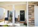Inviting front porch with stone accents, rocking chairs, and a welcoming 'Welcome' sign at 612 Marian Way, Sanford, NC 27330