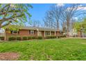 Classic brick home with mature landscaping, including manicured bushes and a green lawn at 709 S Sellars Mill Rd, Burlington, NC 27217