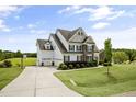 Charming home featuring a three-car garage, large lawn and manicured shrubbery at 71 Del Corso Ct, Clayton, NC 27527