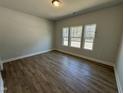 Bedroom with hardwood floors and three windows providing natural light at 761 Portland Rose Dr, Knightdale, NC 27545