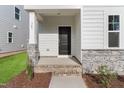 Inviting front porch with stone accents and black front door at 761 Portland Rose Dr, Knightdale, NC 27545