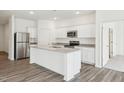 Bright kitchen featuring white cabinets, granite countertops, stainless steel appliances, and a kitchen island with barstool seating at 100 Big Dream Ct, Louisburg, NC 27549