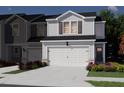 Exterior of new townhome showing a two-car garage, brown shutters, and green landscaping at 1173 Abbott St, Mebane, NC 27302