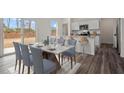 Elegant dining area with marble table, seating for eight, and natural light from sliding glass doors at 12 Rolling Banks Dr, Louisburg, NC 27549
