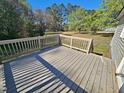 Spacious wooden deck with railing overlooking a large yard at 120 Keith Ct, Willow Springs, NC 27592