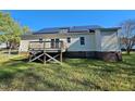 Backyard view of a one-story home with a wooden deck and a spacious lawn at 120 Keith Ct, Willow Springs, NC 27592