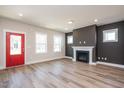 Inviting living room with wood floors, a charming fireplace, a red door, and ample natural light at 123 Weavers Grove Dr, Chapel Hill, NC 27514