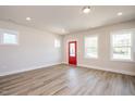 Bright living room with hardwood floors, neutral walls, a red door, and large windows offering natural light at 123 Weavers Grove Dr, Chapel Hill, NC 27514