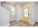 Bright entryway features wood-look floors, a window and a vibrant yellow front door at 123 Weavers Grv Dr, Chapel Hill, NC 27514