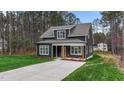 Charming two-story home with dark siding, covered front porch, and well-maintained lawn at 163 Nashua Dr, Louisburg, NC 27549