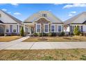 Charming single-story home featuring stone accents, a welcoming front porch, and manicured landscaping at 212 Thunder Forest Ln, Wendell, NC 27591