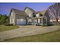 Charming home with inviting front porch, two-car garage, and landscaped front yard with circular driveway at 288 Joseph Alexander Dr, Fuquay Varina, NC 27526