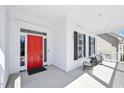 Inviting covered front porch with seating area and a vibrant red front door at 301 Kinsale Dr, Chapel Hill, NC 27517