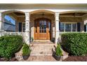 Charming brick home entrance with brick steps, manicured bushes, and a beautiful wooden front door at 321 Weycroft Grant Dr, Cary, NC 27519