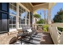 Inviting front porch features comfortable seating, a striped rug, and view to the home's beautiful landscaping at 321 Weycroft Grant Dr, Cary, NC 27519