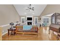 Spacious living room with hardwood floors, a ceiling fan, a fireplace with a decorative mantel, and abundant natural light at 34 Triton Ct, Clayton, NC 27520