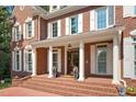 Grand brick home with white columns framing the entrance, decorative lion statues, and a welcoming brick walkway at 405 Silver Creek Trl, Chapel Hill, NC 27514