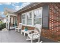 Inviting front porch with brick siding, rocking chairs, and a small table, perfect for relaxing at 411 Circle Dr, Burlington, NC 27215