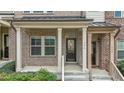 Inviting covered front porch of a townhome with brick pillars and decorative front door at 556 Village Loop Dr, Apex, NC 27502