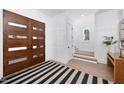 Bright foyer features a wood door and a black and white striped rug on wood floors at 604 Edmund St, Raleigh, NC 27604