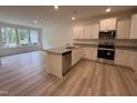 Bright kitchen with stainless appliances, granite countertops, island, and adjacent living area at 6405 Granite Quarry Dr, Raleigh, NC 27610