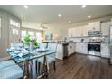 Bright, modern kitchen and dining area with white cabinetry, stainless steel appliances, and a stylish glass dining set at 6405 Granite Quarry Dr, Raleigh, NC 27610