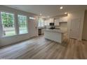 Bright kitchen featuring white cabinets, stainless steel appliances, and a center island with granite countertops at 6407 Granite Quarry Dr, Raleigh, NC 27610