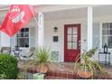 Inviting front porch with seating, decorative plants and a red front door creating a warm and welcoming entry at 711 S East Street St, Raleigh, NC 27601