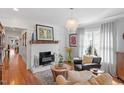 Cozy living room with hardwood floors, a fireplace, and comfortable seating beneath a stylish chandelier at 711 S East Street St, Raleigh, NC 27601