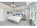 Serene main bedroom with a tray ceiling, soft lighting, and modern decor at 720 Ben Ledi Ct, Raleigh, NC 27603