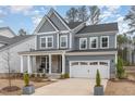 Stylish two-story home with gray siding, stone accents, a welcoming porch, and a convenient two-car garage at 724 Red Arrow Dr, Knightdale, NC 27545