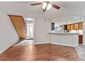 Inviting living area featuring hardwood floors, staircase and a view into the kitchen with a breakfast bar at 7820 Falcon Rest Cir, Raleigh, NC 27615
