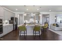 Bright, modern kitchen features an island with pendant lighting, stainless steel appliances, and dark hardwood floors at 800 Emerald Bay Cir, Raleigh, NC 27610