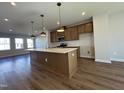Bright kitchen with wood cabinets, stainless appliances, expansive island with white countertops, and pendant lighting at 804 Hillfarm Dr, Wake Forest, NC 27587
