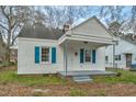 A cozy white home with blue shutters and covered porch is ready to make memories at 824 S Tillery St, Rocky Mount, NC 27803