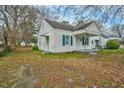 A charming white home with blue shutters and a covered porch is ready for new owners at 824 S Tillery St, Rocky Mount, NC 27803