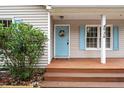 Inviting front porch with blue door, decorative wreath, and light blue shutters, creating a warm welcome at 928 Magnolia Ridge Way, Fuquay Varina, NC 27526