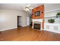 Cozy living room with wood-burning fireplace, built-in shelving, and hardwood floors, perfect for relaxation at 928 Magnolia Ridge Way, Fuquay Varina, NC 27526