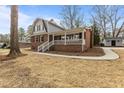 Two-story brick home boasts a classic design and inviting covered porch area at 100 Royall Rd, Oxford, NC 27565
